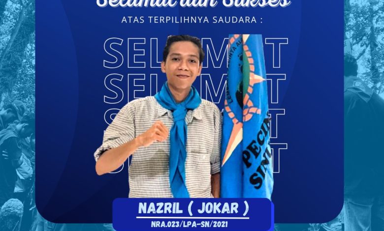 Nazril, ketua terpilih LPA Sinue 2025–2026, berdiri dengan bendera organisasi pecinta alam mengenakan slayer biru, simbol komitmen terhadap alam dan regenerasi organisasi.