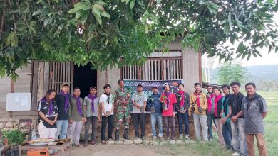 LPA Santalum bersama Babinsa, aparat Desa Pombewe, dan komunitas memegang bibit pohon sebelum penanaman di bantaran Sungai Paneki.