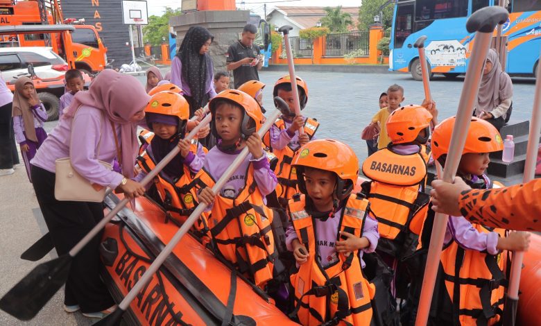 Siswa mengenakan rompi pelampung dan helm keselamatan dalam sesi pengenalan peralatan SAR di Kantor Basarnas Palu.