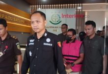 Tersangka kasus dugaan gratifikasi proyek olahan pakan di Kabupaten Sigi digiring petugas keluar dari Kantor Kejaksaan Negeri Sigi usai penetapan tersangka, Selasa (19/5/2026). Penyidik mengungkap dugaan fee proyek dipatok 10–20 persen dari nilai pekerjaan.