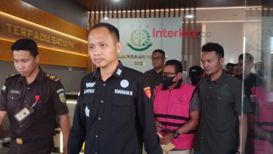 Tersangka kasus dugaan gratifikasi proyek olahan pakan di Kabupaten Sigi digiring petugas keluar dari Kantor Kejaksaan Negeri Sigi usai penetapan tersangka, Selasa (19/5/2026). Penyidik mengungkap dugaan fee proyek dipatok 10–20 persen dari nilai pekerjaan.